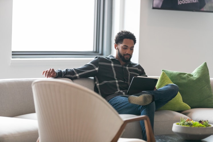 A man in a couch working in his laptop